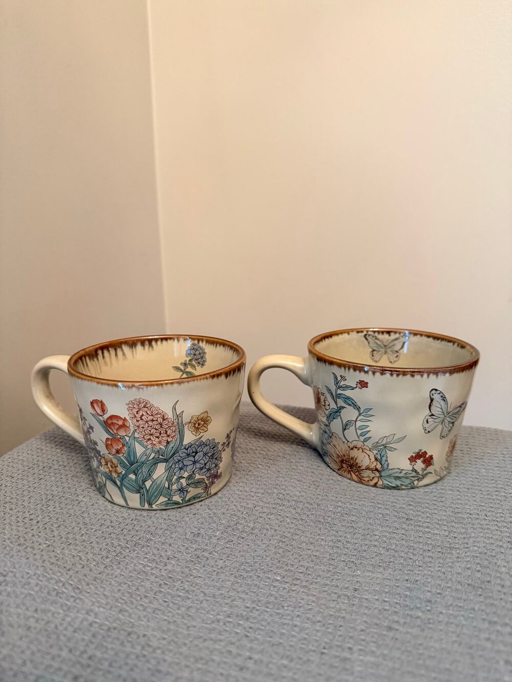 Two new beige ceramic mug features a delicate botanical design with rustic rim